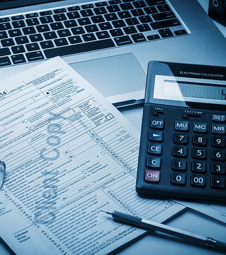 Desktop with laptop, calculator, and tax form
